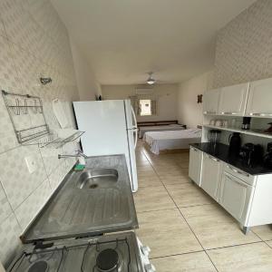 乌巴图巴Carpi Apartamentos Ubatuba的厨房配有水槽和白色冰箱