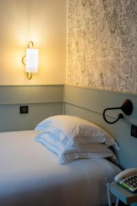 巴黎德福乐西酒店的一间卧室配有一张带台灯和桌子的床