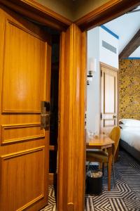 巴黎德福乐西酒店的通往带桌子和床的房间的门