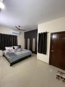海得拉巴Bigson Service Apartments, Kondapur的一间卧室配有一张床、黑色橱柜和一扇门