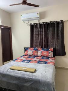 海得拉巴Bigson Service Apartments, Kondapur的一间卧室配有一张带吊扇的床