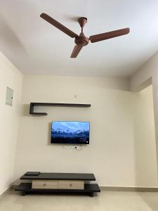 海得拉巴Bigson Service Apartments, Kondapur的客厅配有吊扇和平面电视。