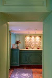 巴黎德福乐西酒店的厨房配有绿色橱柜和台面