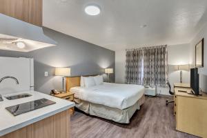盐湖城Suburban Studios Salt Lake City Airport的酒店客房设有床和水槽