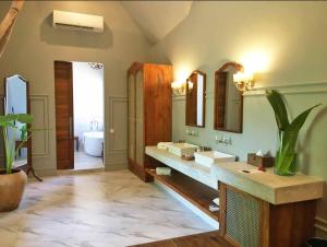 米查维Upendo Beach Boutique Hotel Zanzibar的大型浴室设有两个盥洗盆和浴缸。