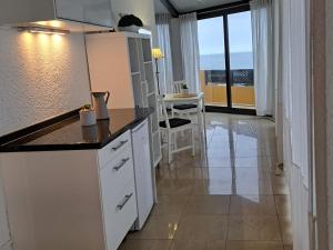 拉克鲁斯Heaven In Canary Islands 88的一间厨房,配有白色的橱柜,享有海景