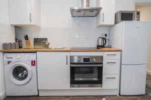 韦克菲尔德VICHY - The Thornhill Delux Apartments的厨房配有冰箱和洗衣机。
