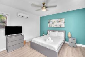 达尼亚滩Blue Wave Bungalow - 1 1 - Stylish的一间卧室配有一张床和一台平面电视