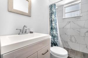 达尼亚滩Blue Wave Bungalow - 1 1 - Stylish的白色的浴室设有水槽和卫生间。