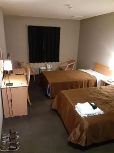 泉佐野HOTEL SEAGULL - Vacation STAY 04630v的酒店客房带两张床和一张桌子以及椅子。