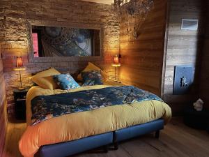 Saint-Étienne-lès-RemiremontL'ANNEXE的卧室配有一张床铺,位于带木墙的房间内