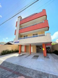 邦比尼亚斯Residencial 364 - Localização privilegiada à 5min da praia的前面有橙色柱子的建筑