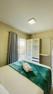 邦比尼亚斯Residencial 364 - Localização privilegiada à 5min da praia的一间卧室配有带毛巾的床