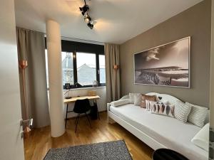 菲拉赫Luxury Apartment Villach City的客厅配有白色沙发和书桌