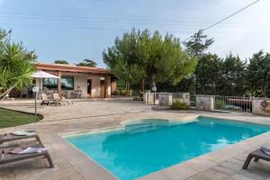 奥斯图尼Villa Sorbole的一座带房子的庭院内的游泳池