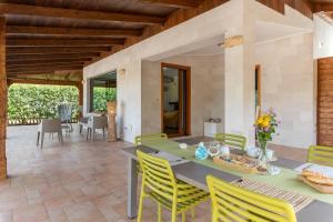 奥斯图尼Villa Sorbole的一间带桌子和黄色椅子的用餐室