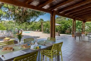 奥斯图尼Villa Sorbole的一个带桌椅的庭院和一个游泳池