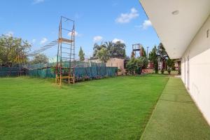 古尔冈Palette - JPS Residency的一个带游乐场的大型草地庭院