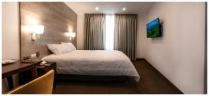 HuancavelicaLA TERRAZA INN的酒店客房设有一张大床和一张书桌。