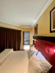 卡萨布兰卡Appart Hôtel Oleandro的一间卧室配有一张大床和红色床头板