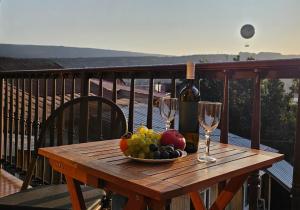 第比利斯7客房酒店的一张木桌,上面放着一碗水果和酒杯