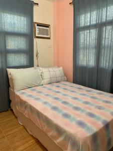 SisonDuran Pool & Guesthouse的一间卧室配有一张带蓝色窗帘的大床