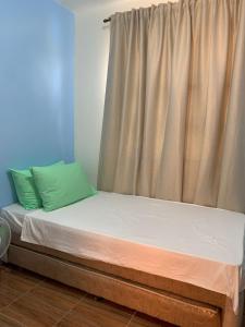 SisonDuran Pool & Guesthouse的床上床,床边有窗帘和床边的西德克斯