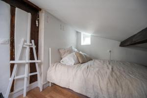 勒瓦卢瓦-佩雷Beautiful duplex on the outskirts of Paris - Welkeys的白色的卧室,配有床和梯子