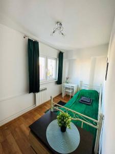 华沙City View Rooms的一间设有一张床和一张桌子及绿毯的房间