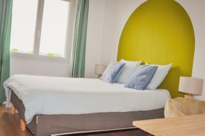 特鲁瓦Les Chambres de Troyes - Parking Free Fibre Netflix的一间卧室设有一张黄色墙壁的大床