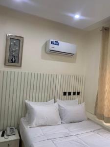 阿布贾Bott Extended Stay的酒店客房的墙上设有一张带空调的床。
