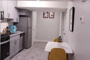埃德蒙顿Deluxe 2 bedroom suite with*Netflix/Cable/Prime的厨房配有白色橱柜和桌椅