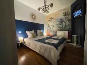 南希Le Relais des Cordeliers的一间卧室设有一张蓝色墙壁的大床