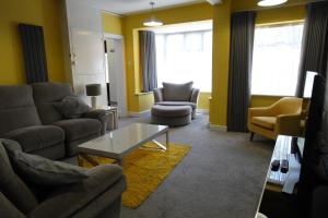 伯明翰Huge 9 Bed Property Sleeps 17, Near NEC, City Centre, HS2的客厅配有沙发、椅子和桌子