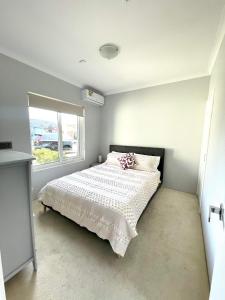 珀斯Ocean Reef Retreat的卧室配有一张带白色棉被的床和窗户。