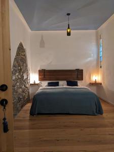戈里齐亚Castel San Mauro的一间卧室设有一张大床和石墙