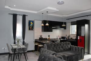 MunyonyoMHP Apartments的客厅以及带沙发和桌子的厨房。