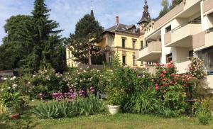 葡萄酒之路上的诺伊施塔特Wohlfühl & Wellness Oase的一座花园,在一座建筑前种有鲜花