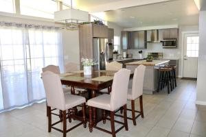 拉斯克鲁塞斯Sleek, Modern Designer home 3的厨房以及带木桌和椅子的用餐室。