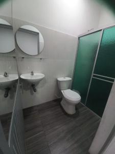 Hotel Oiti的一间带卫生间、水槽和镜子的浴室
