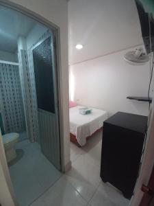 Hotel Oiti的小房间设有床和通往浴室的门