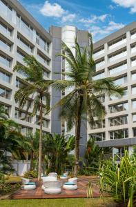 利伯维尔利伯维尔奥古曼皇宫丽笙酒店的一座大建筑前的棕榈树