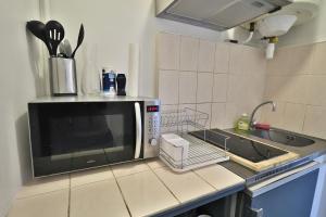 蒙贝利亚尔Studio de 30m² hypercentre très calme的厨房配有微波炉和水槽