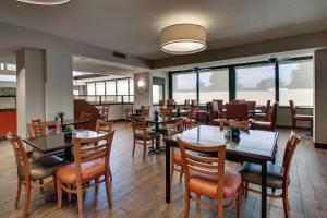 埃文斯维尔埃文斯维尔东特鲁利套房酒店的用餐室设有桌椅和窗户。