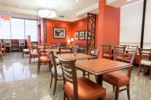 埃德蒙逊德鲁里圣路易斯机场套房酒店的用餐室配有木桌和椅子