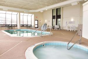 埃德蒙逊德鲁里圣路易斯机场套房酒店的一个带桌椅的房间的游泳池