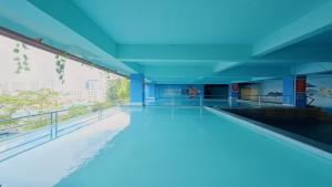 名古屋King's Hotel Nagoya Batam的一座带蓝色天花板的建筑中的游泳池