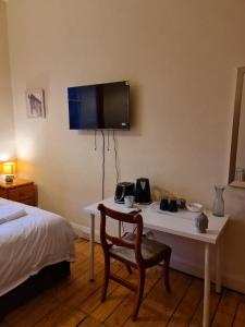 爱丁堡Haymarket Station Rooms的一间设有一张床和一张桌子的房间,墙上设有一台电视