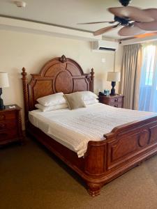 卡帕阿珊瑚礁酒店的一间卧室配有一张大床和木制床头板