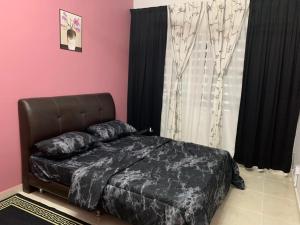 瓜拉丁加奴ALEENA STAYCATION @ APARTMENT TOK PELAM PANTAI BATU BURUK的一间卧室配有一张带黑色床罩的床